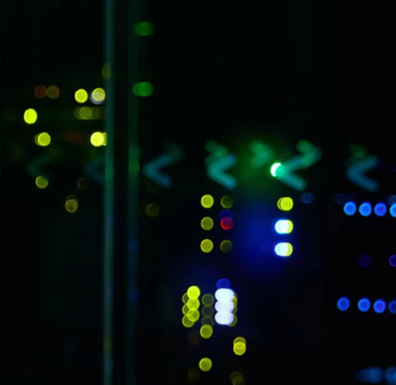 Pasillo de un datacenter con racks APC y las luces de los equipos encendidas